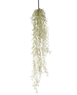 Una planta colgante artificial Hierba de 91 cm con hojas largas y colgantes de color verde claro cuelga de un cordón negro sobre un fondo blanco liso.