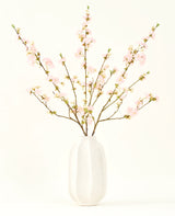 El ramo de flores artificiales de seda Flor de cerezo rosa claro de 94 cm presenta delicadas flores de cerezo artificiales de color rosa en un jarrón de cerámica blanca, que añade elegancia sobre un fondo claro y liso.