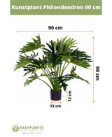 Planta artificial Filodendro UV de 90 cm en maceta negra, con hojas de 90 cm de ancho. Perfecto para cualquier espacio. Tamaño de la maceta: 12 cm de alto, 13 cm de ancho. Logotipo Easyplants en la parte inferior.
