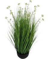 La maceta de césped artificial con flor de puerro y cebolla de 100 cm retardante de fuego es una planta de césped artificial en una maceta con hojas largas y delgadas y pequeños racimos de flores blancas en una maceta redonda negra, representada sobre un fondo blanco liso.