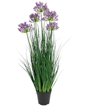 La maceta de césped artificial Agapanthus Onion Grass de color morado es una planta artificial ignífuga de 90 cm de altura con largas hojas verdes y racimos de flores de color violeta, expuestas en una maceta negra lisa sobre un fondo blanco.
