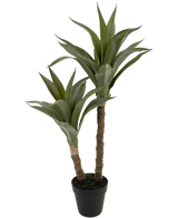 La Planta Artificial Agave 76 cm tiene dos tallos largos y gruesos con hojas verdes puntiagudas que recuerdan a un agave, presentada en una maceta de plástico negra sobre un fondo liso blanco.