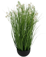 La maceta de hierba de cebolla con flor de Gesang blanca de Césped Artificial es una planta artificial ignífuga de 90 cm con hojas verdes largas y delgadas y delicadas flores blancas en una maceta negra redonda, sobre un fondo blanco liso.