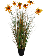 La maceta de césped artificial con crisantemo y cebolla de 90 cm retardante de fuego tiene hojas altas, verdes y marrones, parecidas a la hierba, con siete flores de margaritas artificiales de color naranja en una maceta negra, sobre un fondo blanco.