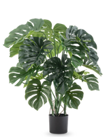 De Kunstplant Monstera 90 cm heeft grote, gespleten groene bladeren en wordt geleverd in een zwarte pot, tegen een effen witte achtergrond.