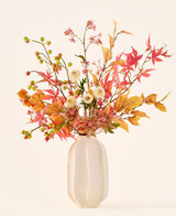 Ramo de flores artificiales de seda 'Autumn Breeze' en jarrón de cerámica blanca, con hojas de otoño, pequeñas bayas verdes, flores rosas y flores blancas, elaborado con flores de seda de alta calidad. Colocado sobre un fondo claro, el ramo de flores artificiales perfecto para dar a cualquier habitación una atmósfera estacional duradera.