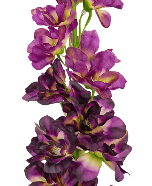 Un primer plano de la Flor Artificial Delphinium Púrpura de 79 cm, un tallo artificial alto con múltiples flores de color violeta y violeta oscuro con un corazón verde y amarillo, sobre un fondo blanco.