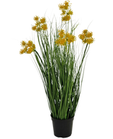 Un bonsái de hierba artificial de raíz de hierba, cebolla, 60 cm de altura e ignífugo, con finas hojas verdes y racimos de flores amarillas en tallos largos, sobre un fondo blanco liso.